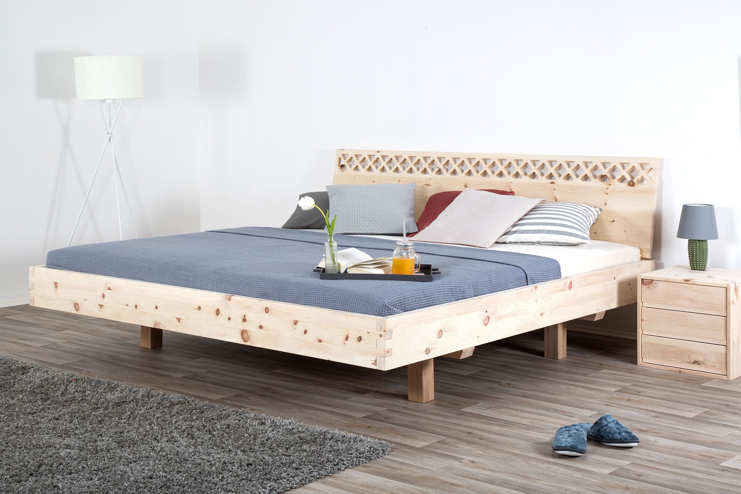 Schräge Frontalansicht des Bettes Ajuru 06 mit verzierter Rückenlehne