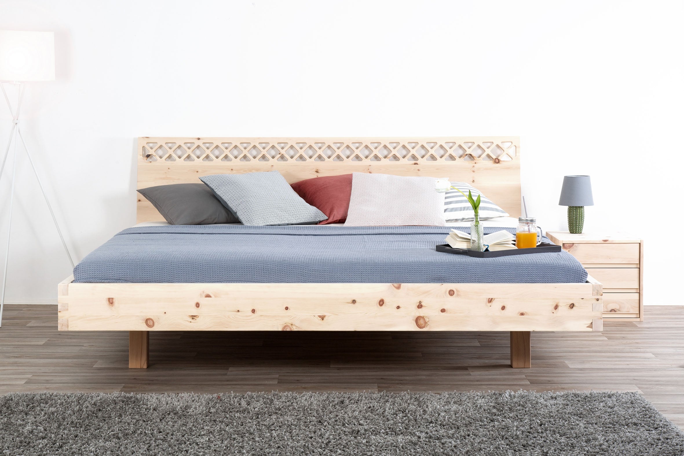 Frontalansicht des Bettes Ajuru 06 mit verzierter Rückenlehne