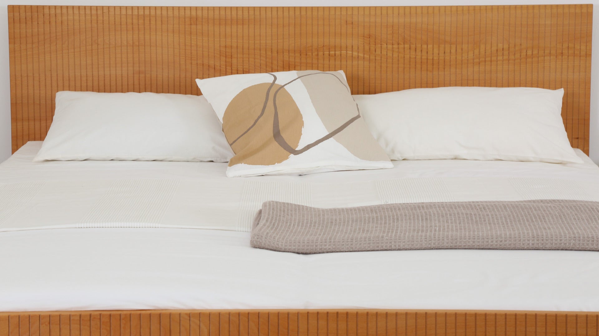 Detailansicht Rückwand mit gefrästem Streifen-Design von Bett Aikana in Buche