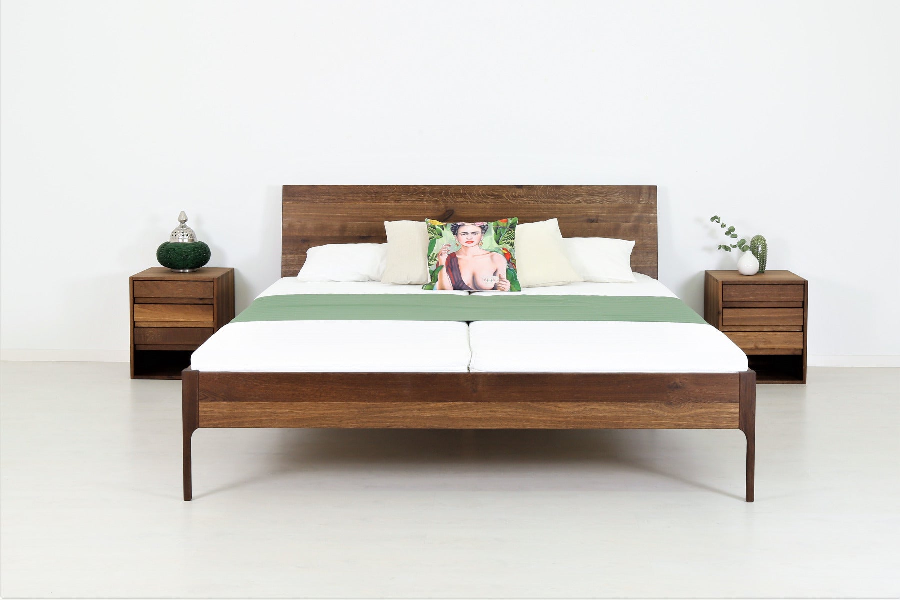 Frontalansicht von Bett Ona 01 in Eiche geräuchert mit filigranen Füßen und schlichter rechteckiger Rückenlehne