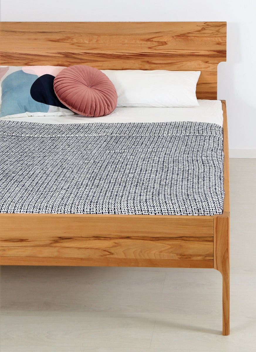 Frontalansicht von Bett Noa Tai in Kernbuche mit filigranen Holzfüßen und Designerlehne
