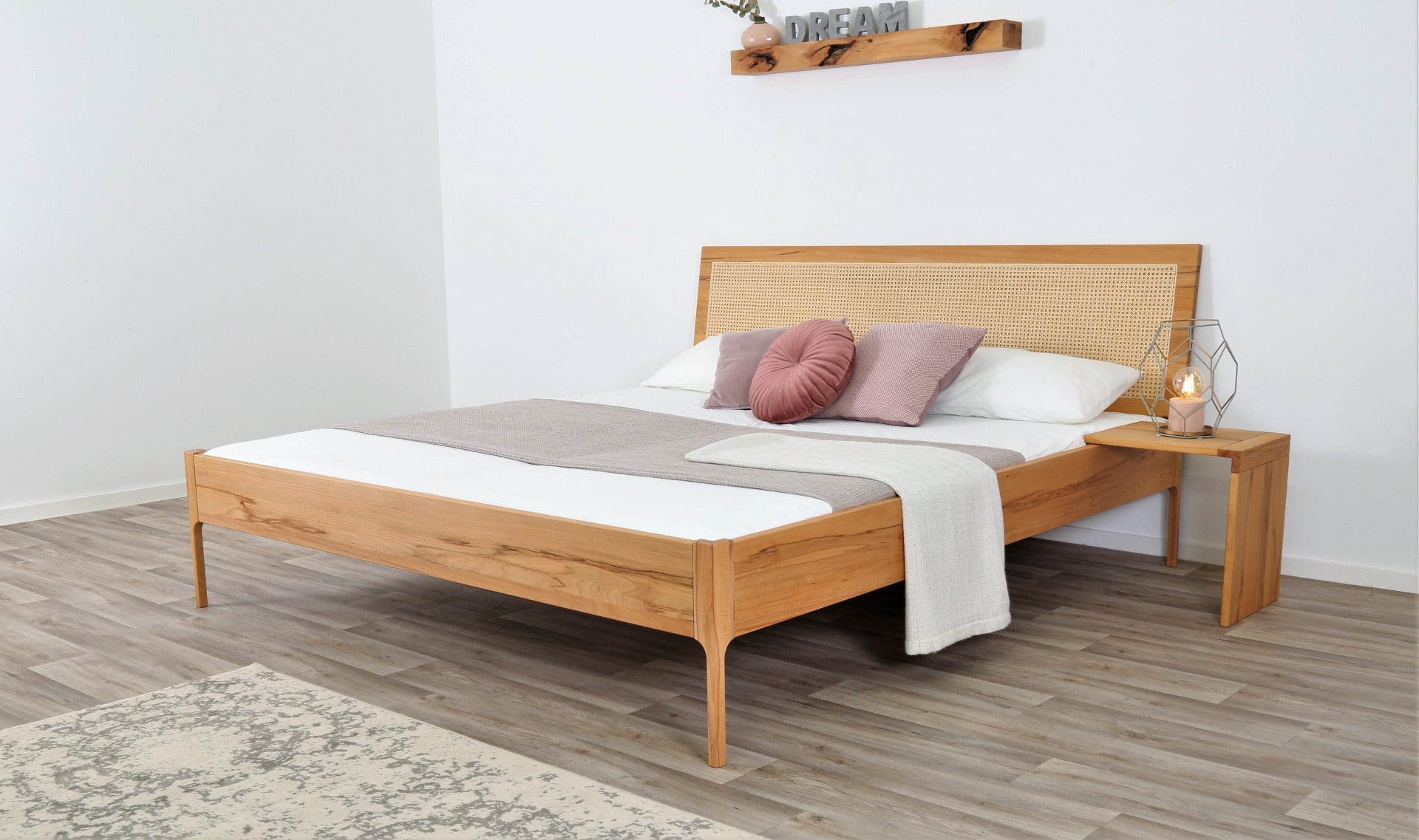 Schräge Frontalansicht von Bett Ona Vienna in Kernbuche mit Wiener Geflecht Rückenlehne und filigranen Füßen