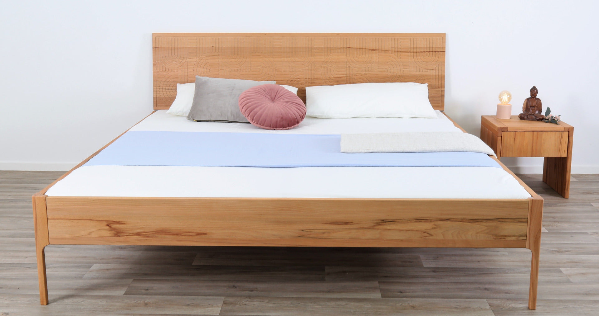 Frontalansicht von Bett Ona Zen in Kernbuche mit filigran gefräster Lehne und filigranen Füßen