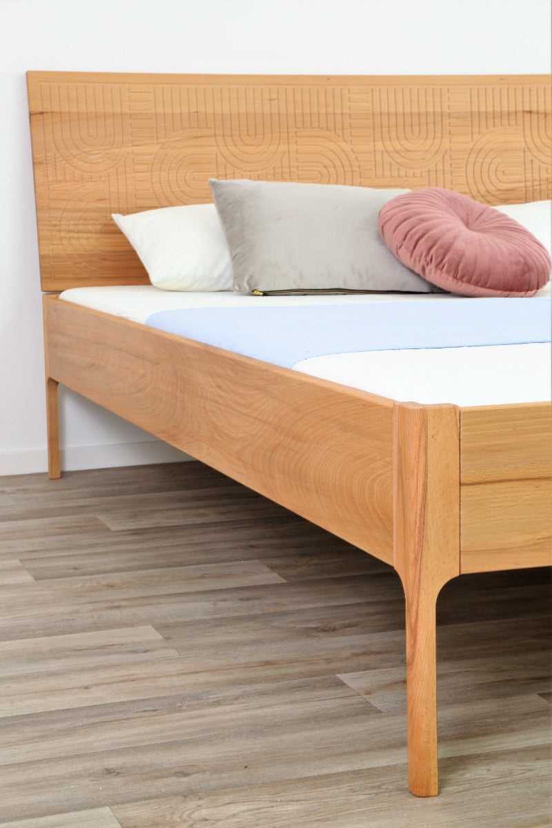 Detailansicht der filigran gefrästen Lehne und der filigranen Füße von Bett Ona Zen in Kernbuche