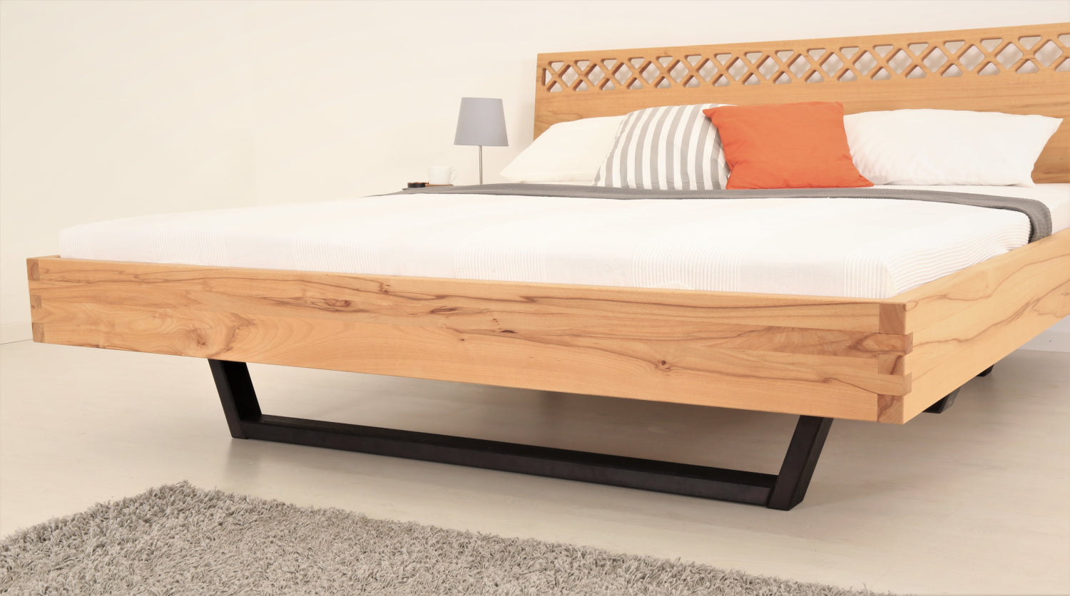 Schräge Frontalansicht von Bett Cofan mit Kufe aus schwarz gebeizt/geölter Buche und orientalischer Rücklehne