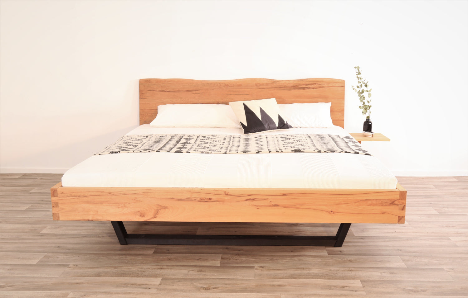 Frontalansicht von Bett Cofan mit Kufe aus schwarz gebeizter/geölter Buche und Baumkanten-Lehne