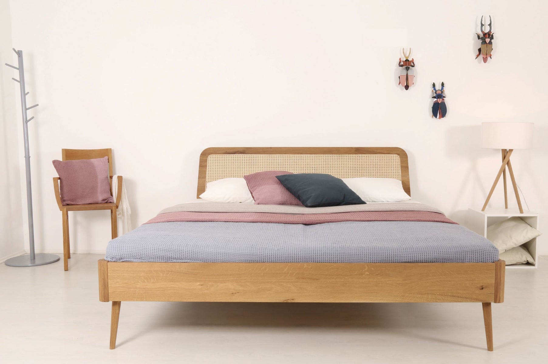 Frontalansicht von Bett Prina mit filigranen, kegelförmigen Füßen und Wiener-Geflecht-Lehne