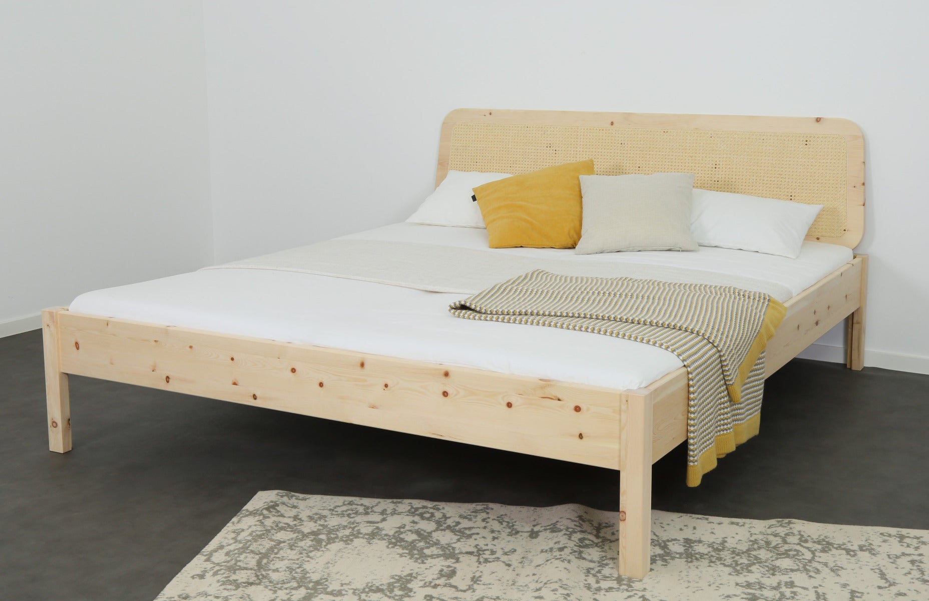 Schräge Frontalansicht von Bett Toba in Zirbe mit Wiener Geflecht Lehne