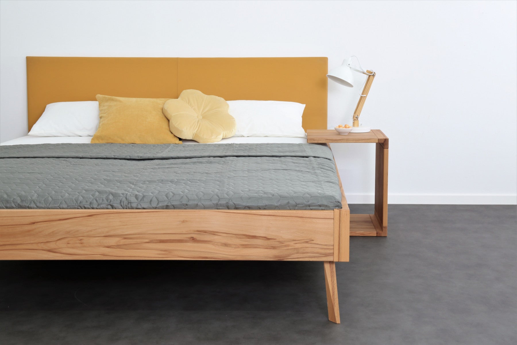 Frontalansicht von Bett Tuxa Premium mit filigranen Füßen und Rinderlederlehne in Kurkuma