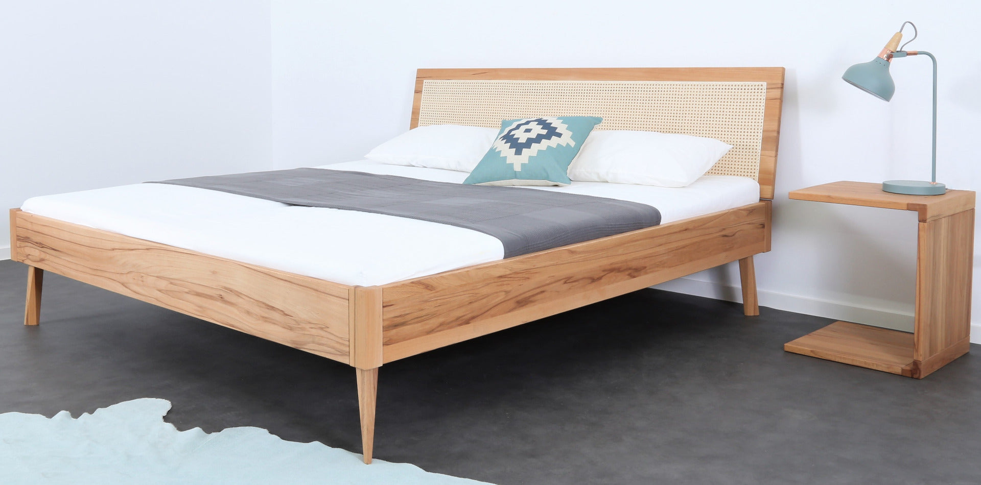 Schräge Frontalansicht von Bett Tuxa Vienna mit Wiener Geflecht Rückenlehne und filigranen Holzfüßen