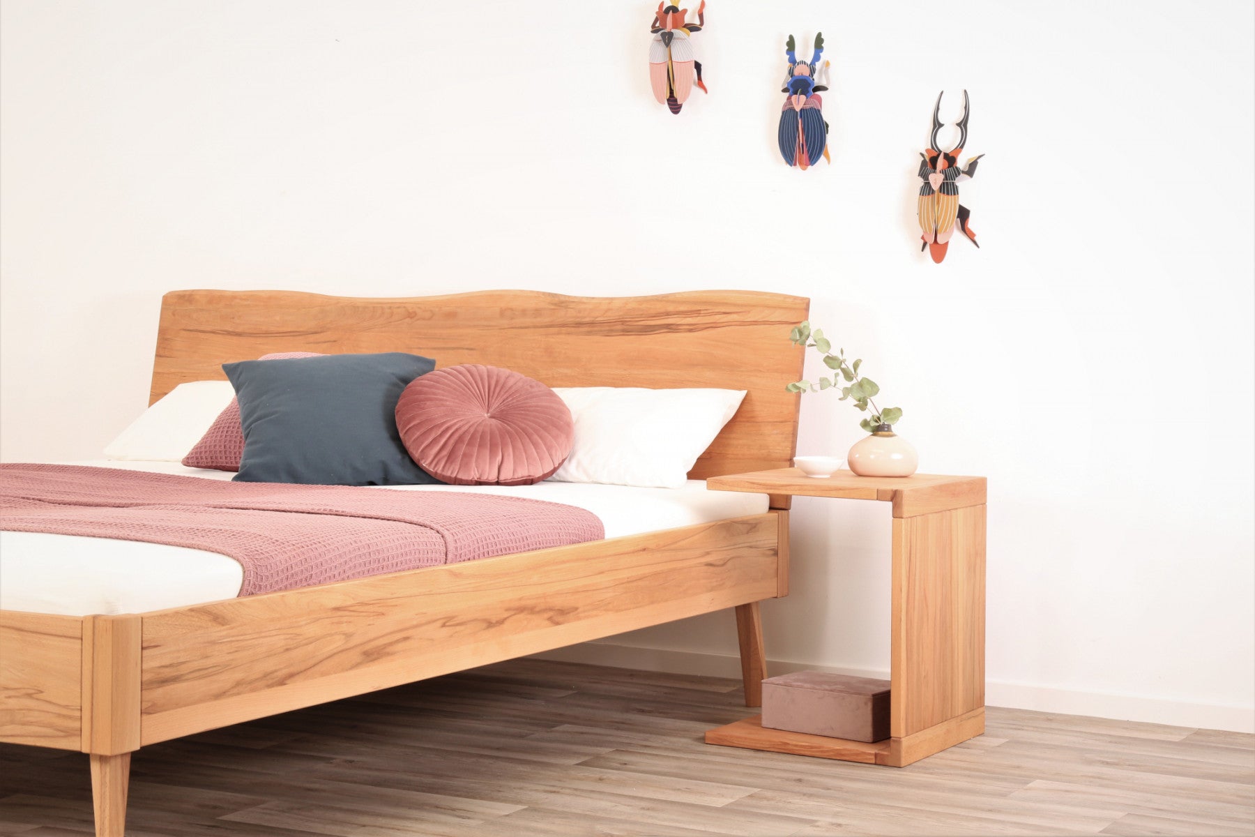 Schräge Frontalansicht von Bett Tuxa Wood in Kernbuche mit filigranen Füßen und Baumkantenlehne