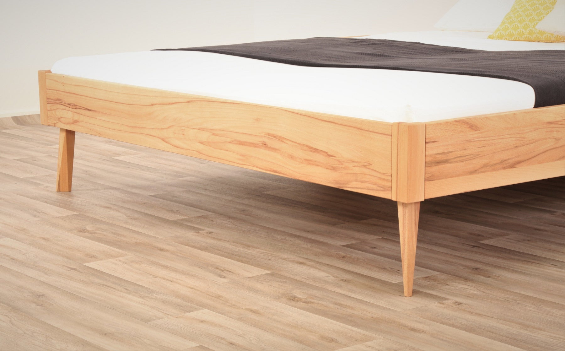 Detailaufnahme der filigranen Füße von Bett Tuxa in Kernbuche