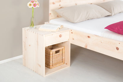 Schräge Frontalansicht von Nachttisch Ainu 1 mit einem Schubfach und einer Ablage, in der ein kleiner geflochtener Korb steht.