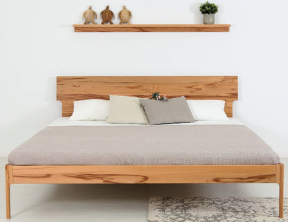Frontalansicht von Bett Noa Tai in Kernbuche mit filigranen Holzfüßen und Designerlehne