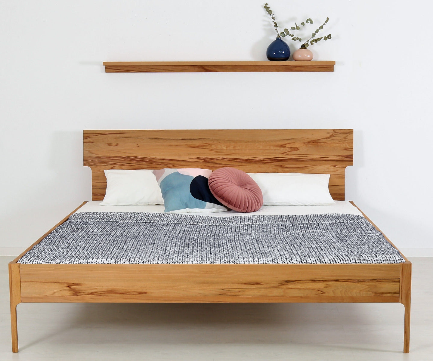 Frontalansicht von Bett Noa Tai in Kernbuche mit filigranen Holzfüßen und Designerlehne