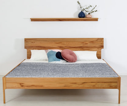 Frontalansicht von Bett Noa Tai in Kernbuche mit filigranen Holzfüßen und Designerlehne