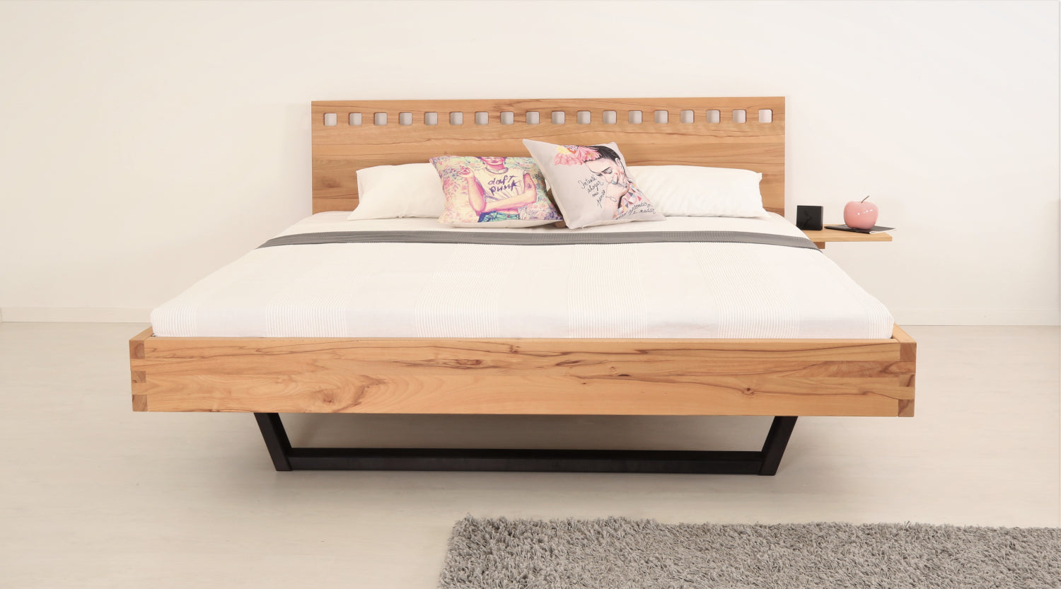 Frontalansicht von Bett Cofan mit Kufe aus schwarz gebeizter/geölter Buche und Lehne mit quadratischen Durchbrüchen
