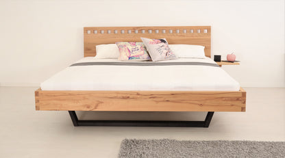 Frontalansicht von Bett Cofan mit Kufe aus schwarz gebeizter/geölter Buche und Lehne mit quadratischen Durchbrüchen