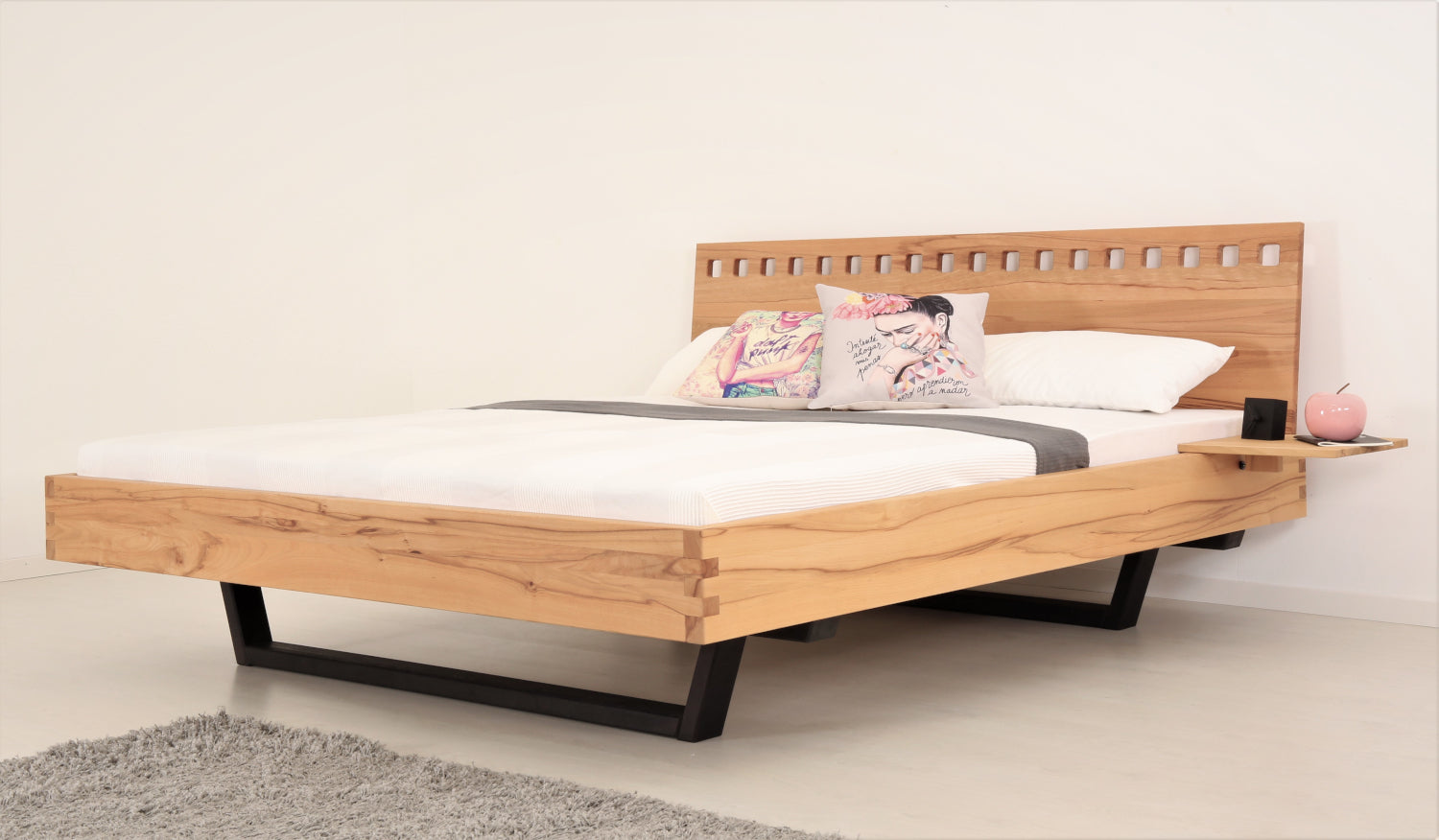 Schräge Frontalansicht von Bett Cofan mit Kufe aus schwarz gebeizter/geölter Buche und Lehne mit quadratischen Durchbrüchen