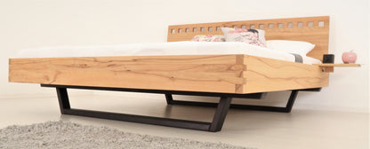 Schräge Frontalansicht von Bett Cofan mit Kufe aus schwarz gebeizter/geölter Buche und Lehne mit quadratischen Durchbrüchen