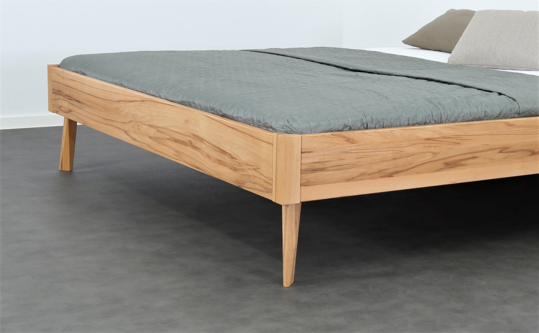 Detailaufnahme der filigranen Füße von Bett Tuxa als Liege in Kernbuche