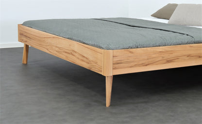 Detailaufnahme der filigranen Füße von Bett Tuxa als Liege in Kernbuche