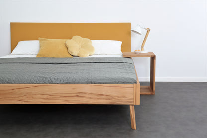 Frontalansicht von Bett Tuxa Premium mit filigranen Füßen und Rinderlederlehne in Kurkuma